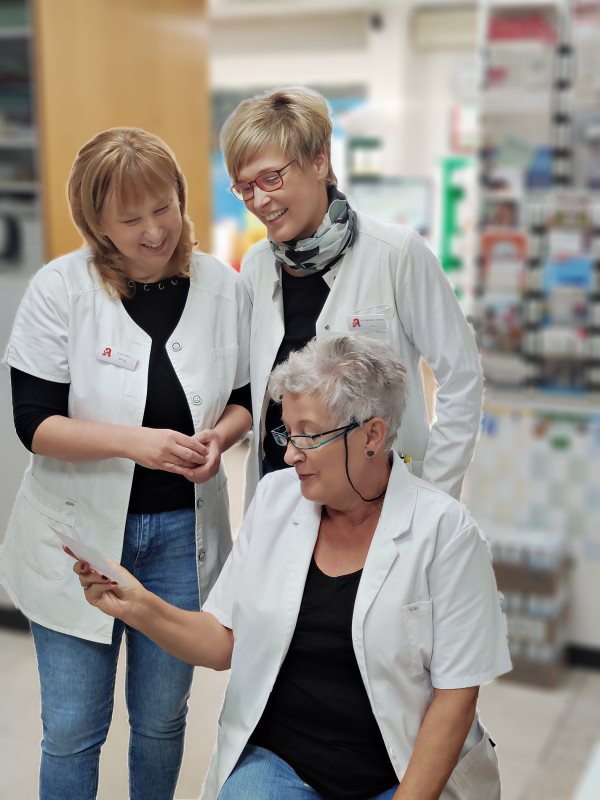 Drei Mitarbeiterinnen der Markt-Apotheke schauen gemeinsam auf ein Rezept